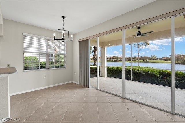 unfurnished dining area featuring plenty of natural light, a water view, and light tile patterned floors