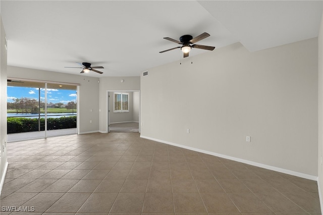 empty room with ceiling fan and tile patterned flooring