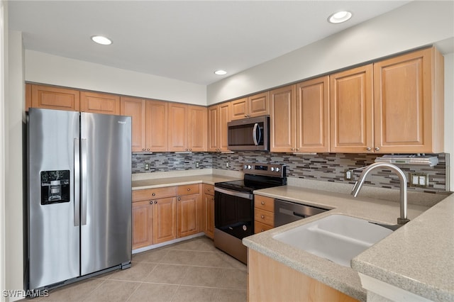 kitchen with light tile patterned floors, stainless steel appliances, tasteful backsplash, and sink