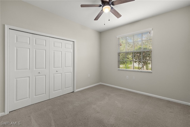 unfurnished bedroom featuring a closet, light colored carpet, and ceiling fan