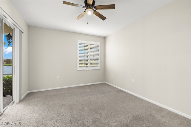 carpeted spare room featuring ceiling fan