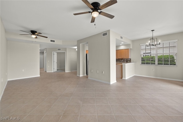 unfurnished living room featuring light tile patterned flooring and ceiling fan with notable chandelier