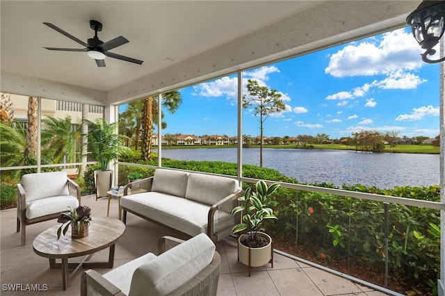 sunroom featuring ceiling fan and a water view