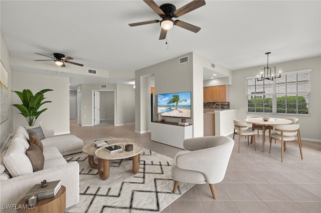 living room with light tile patterned flooring and ceiling fan with notable chandelier