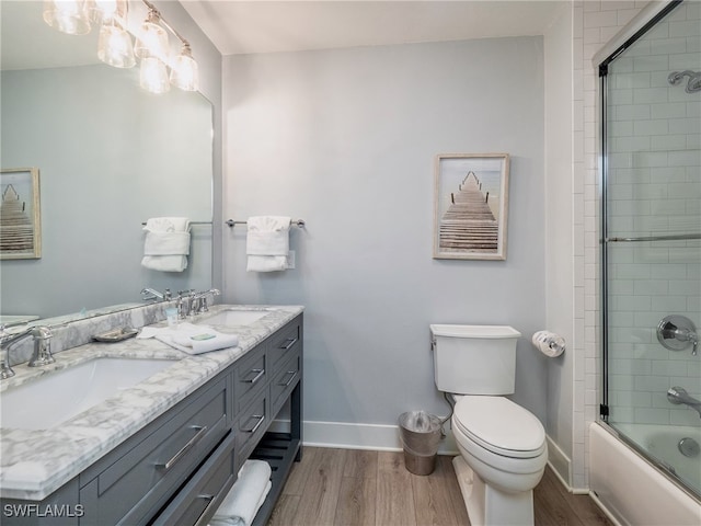 full bathroom featuring hardwood / wood-style floors, vanity, enclosed tub / shower combo, and toilet