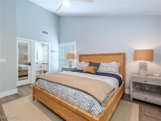 bedroom featuring ceiling fan, hardwood / wood-style floors, and high vaulted ceiling