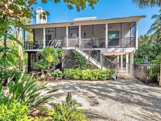 view of front of home with a sunroom, ceiling fan, and covered porch