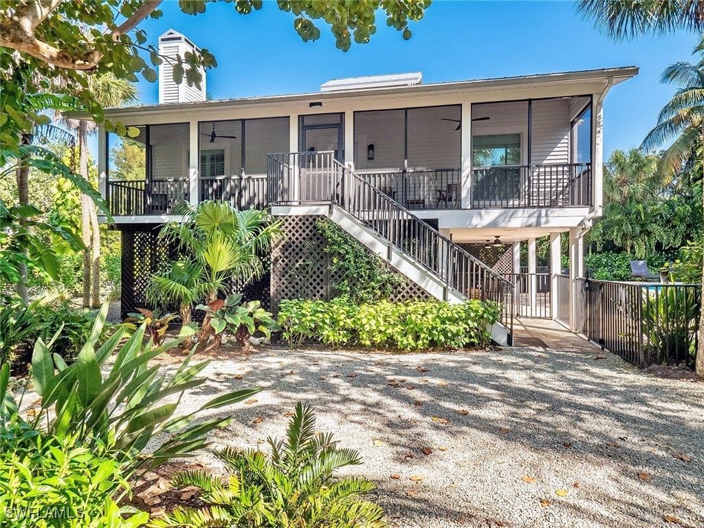 15155 Wiles Dr, Captiva, FL 33924 - beach home featuring a ceiling fan, stairs, a sunroom, and a chimney