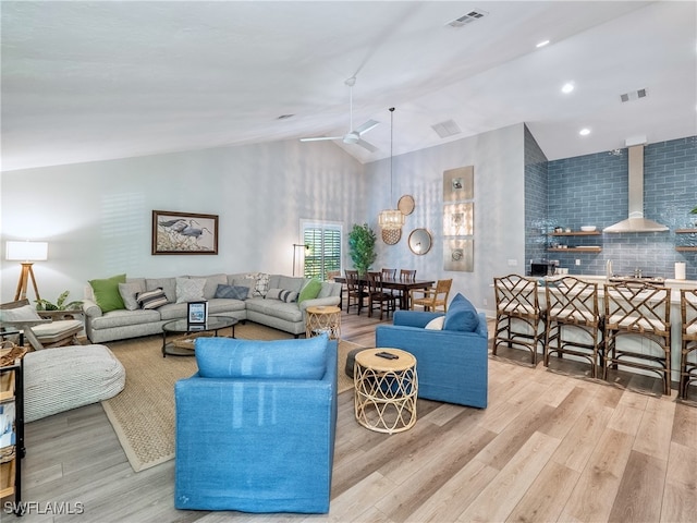 living room with vaulted ceiling, light hardwood / wood-style flooring, and ceiling fan