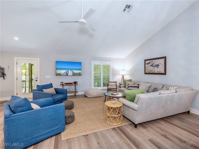 living room featuring ceiling fan, light hardwood / wood-style floors, and vaulted ceiling