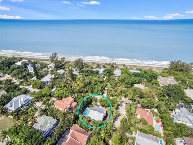 birds eye view of property featuring a beach view and a water view