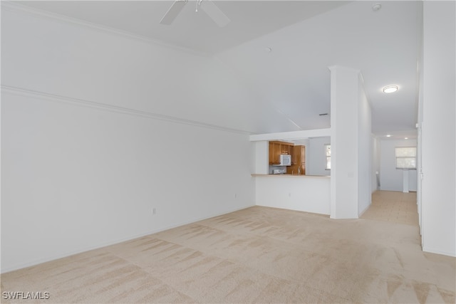 unfurnished living room with high vaulted ceiling, light colored carpet, ceiling fan, and crown molding