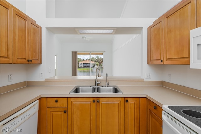 kitchen with kitchen peninsula, sink, and white appliances