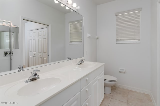 bathroom with toilet, vanity, and tile patterned floors