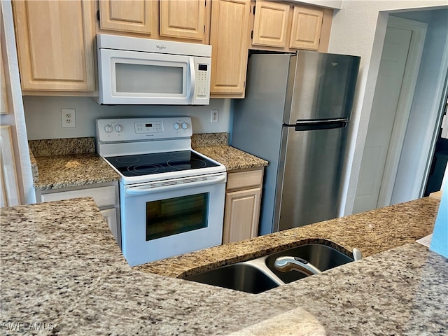 kitchen featuring light brown cabinets, white appliances, sink, and light stone counters