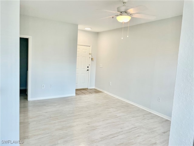 spare room with ceiling fan and light wood-type flooring