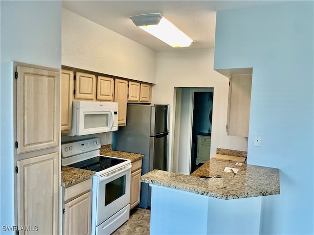 kitchen featuring light brown cabinets, white appliances, light stone counters, and kitchen peninsula