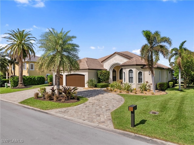 mediterranean / spanish-style home featuring a garage and a front lawn