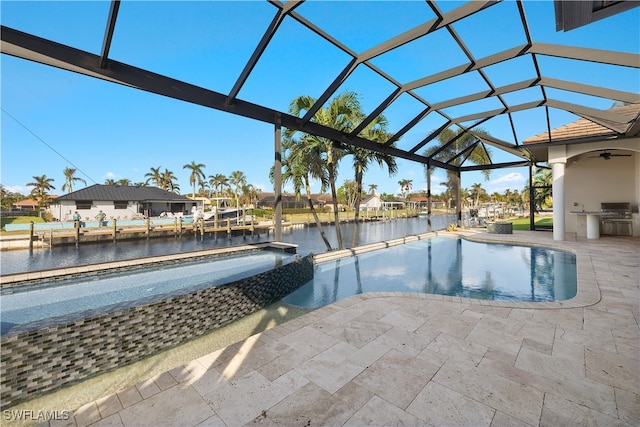 view of swimming pool with an outdoor kitchen, a water view, glass enclosure, and a patio area