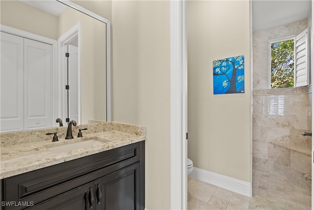 bathroom featuring tiled shower, vanity, and toilet