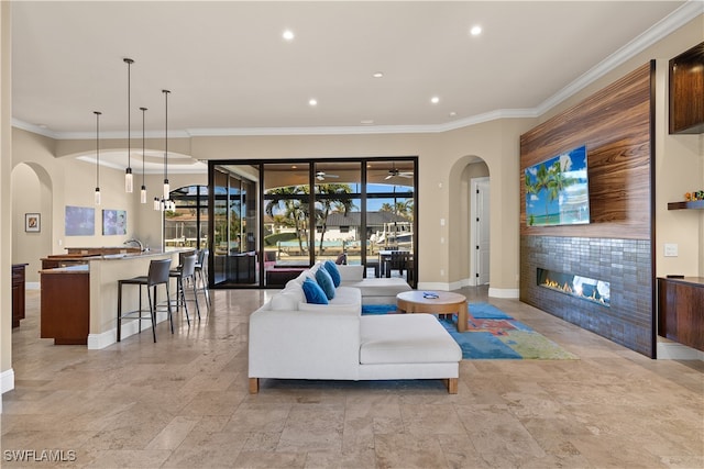 living room featuring ornamental molding and a tile fireplace