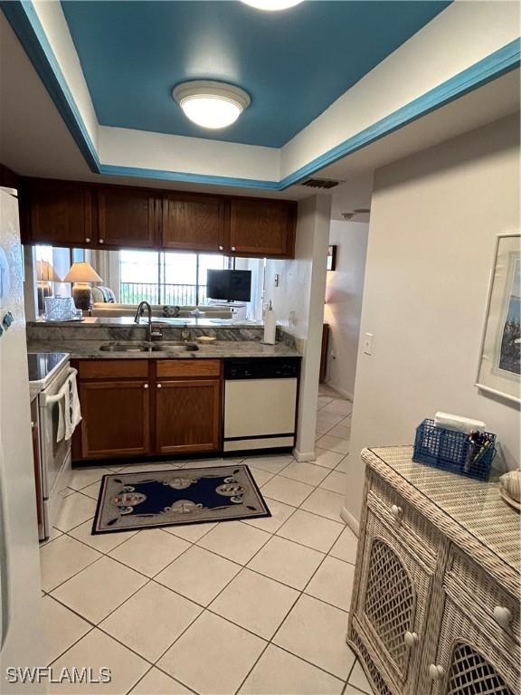 4510 N Key Dr Unit 105, North Fort Myers, FL 33903 - kitchen with white appliances, a sink, a raised ceiling, and light tile patterned floors