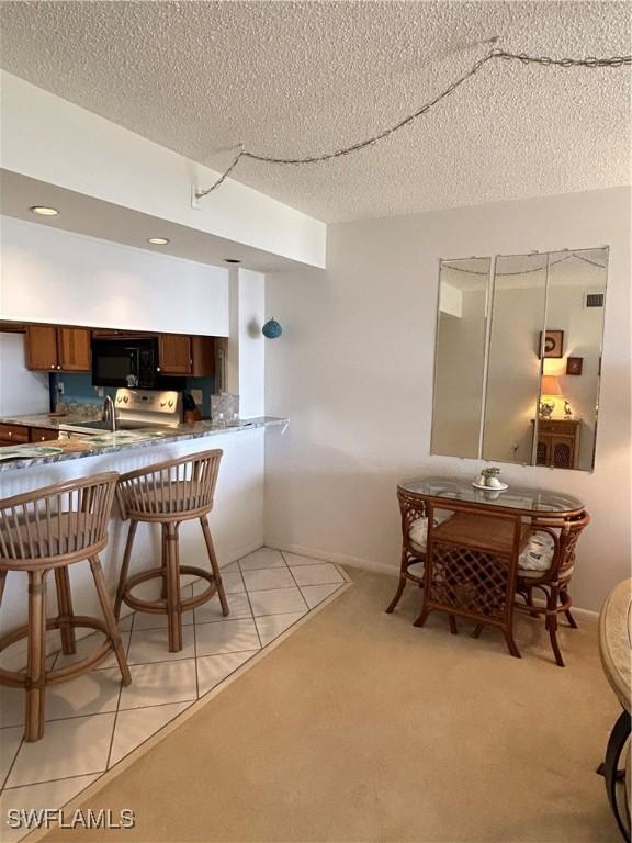 4510 N Key Dr Unit 105, North Fort Myers, FL 33903 - dining area featuring a textured ceiling and light colored carpet