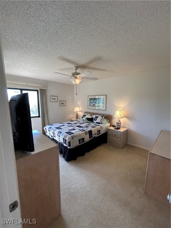 carpeted bedroom featuring a textured ceiling and ceiling fan