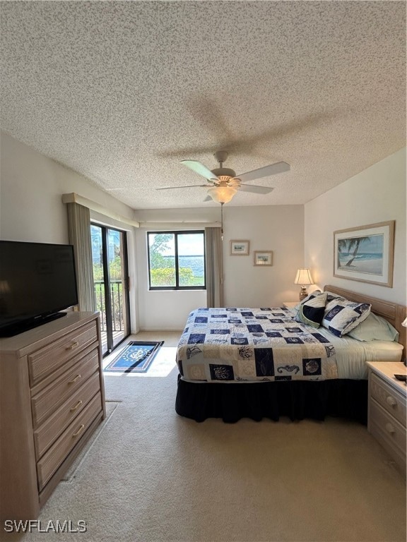 carpeted bedroom with a textured ceiling, ceiling fan, and access to exterior