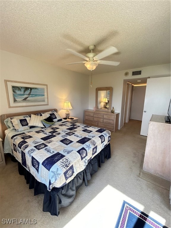 bedroom with ceiling fan, a textured ceiling, and carpet flooring