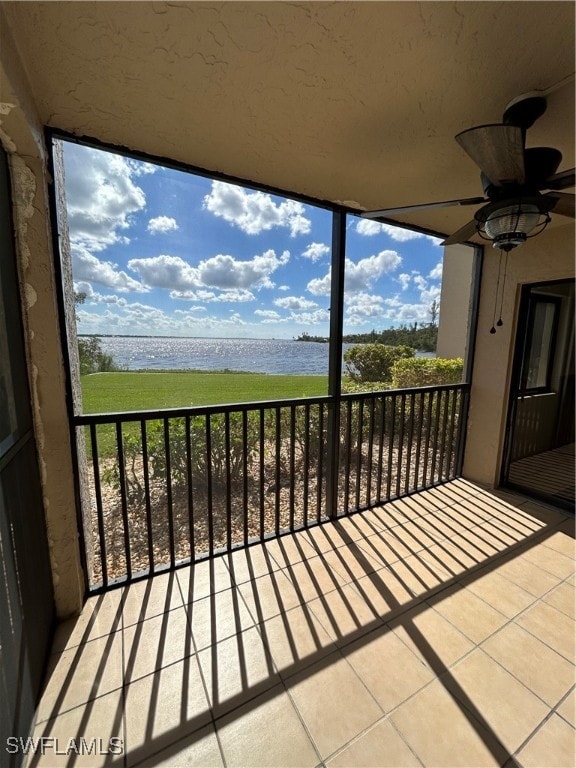 balcony with a water view and ceiling fan