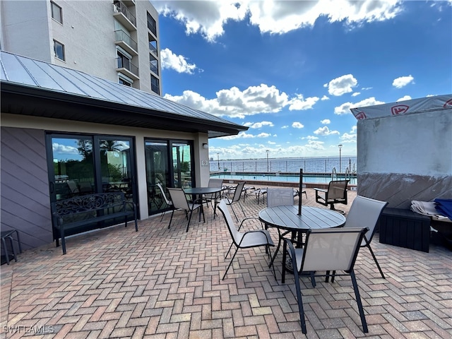 view of patio / terrace with a water view and a community pool