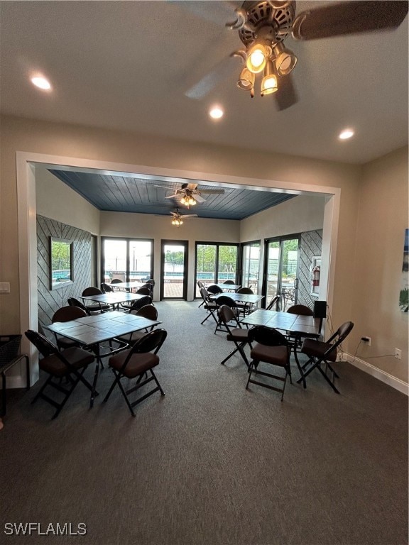 carpeted dining space featuring ceiling fan and plenty of natural light