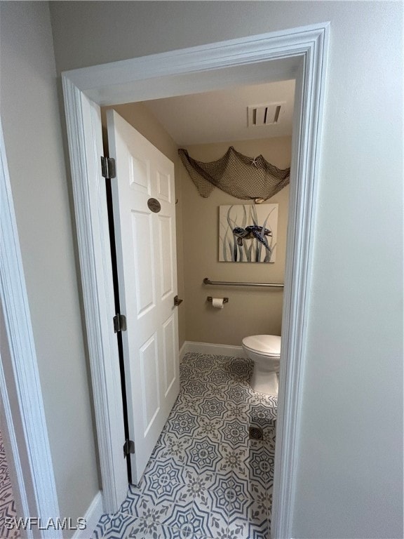 bathroom with toilet and tile patterned floors