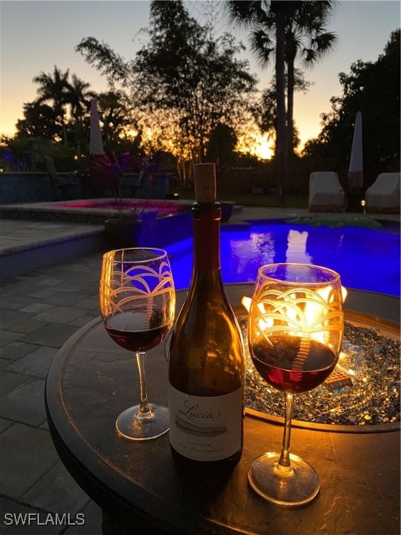 pool at dusk with a patio area