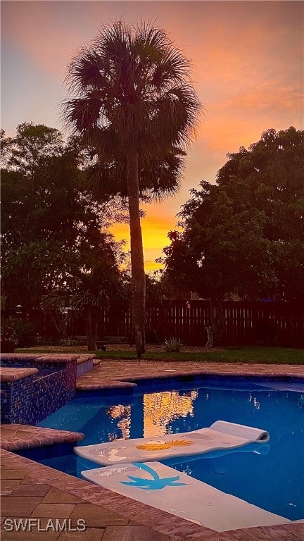 view of pool at dusk