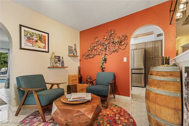 sitting room with a textured ceiling and light tile patterned floors