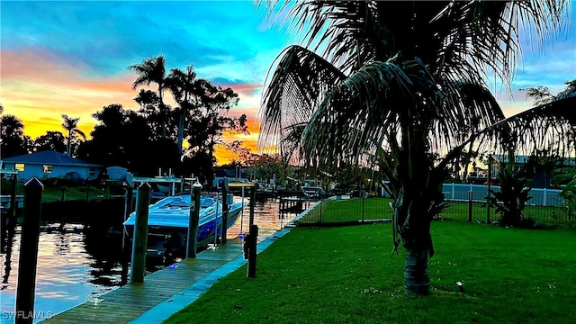 view of dock featuring a water view and a yard