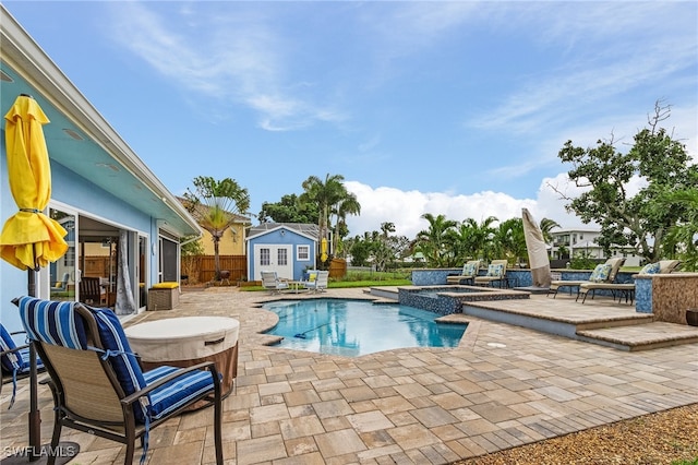 view of swimming pool with an outdoor structure, an in ground hot tub, and a patio area