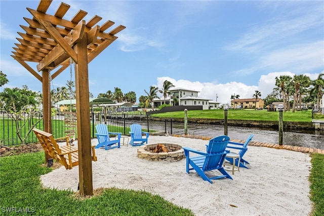 view of play area with a water view, a fire pit, a yard, and a pergola