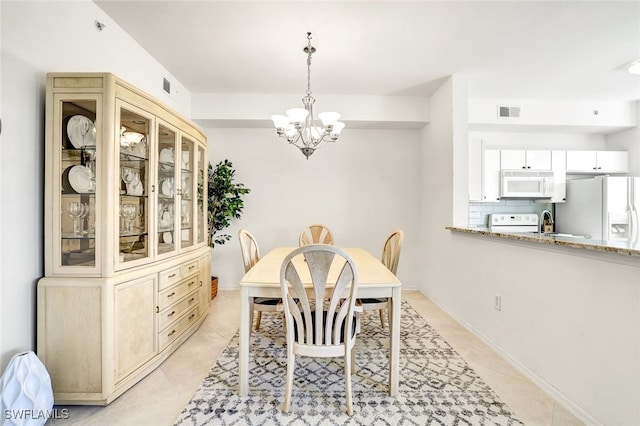 tiled dining area featuring sink and a chandelier