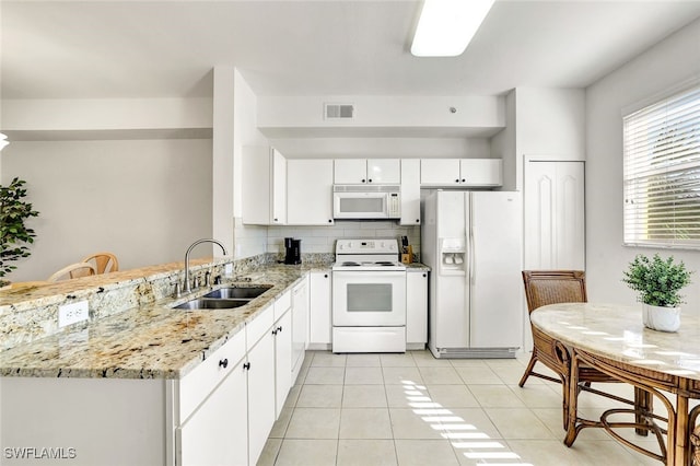 kitchen featuring white appliances, light tile patterned flooring, visible vents, a sink, and white cabinetry