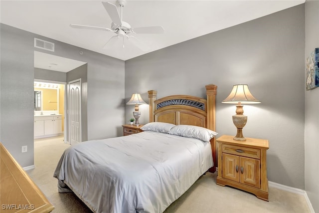 carpeted bedroom with ceiling fan and ensuite bath