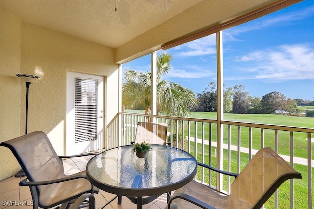 sunroom with golf course view, outdoor dining space, and ceiling fan