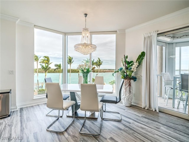 4137 Bay Beach Ln Unit 532, Fort Myers Beach, FL 33931 - dining space with a chandelier, plenty of natural light, ornamental molding, wood finished floors, and a water view