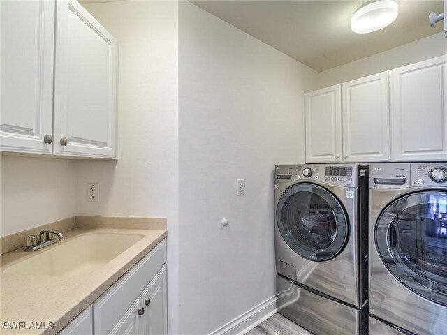 4137 Bay Beach Ln Unit 532, Fort Myers Beach, FL 33931 - washroom with cabinet space, washer and dryer, and baseboards