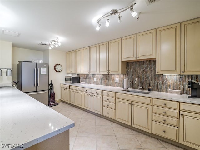 4137 Bay Beach Ln Unit 532, Fort Myers Beach, FL 33931 - kitchen featuring cream cabinetry, stainless steel appliances, a sink, light countertops, and decorative backsplash