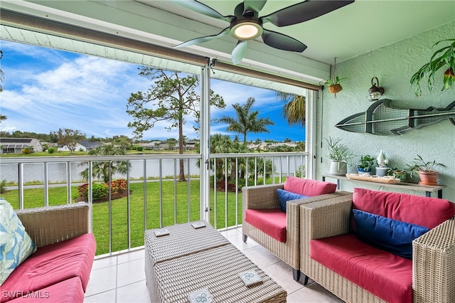 sunroom / solarium with ceiling fan and a water view