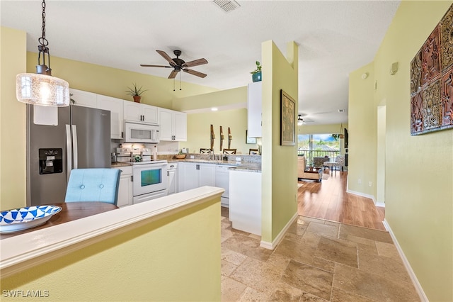 kitchen with sink, hanging light fixtures, kitchen peninsula, white appliances, and white cabinets