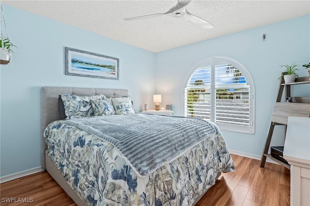 bedroom featuring hardwood / wood-style floors, a textured ceiling, and ceiling fan